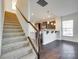 Inviting entryway featuring a staircase and a view into the kitchen with a breakfast bar and dark hardwood floors at 4051 Whittier Ln, Fort Mill, SC 29708