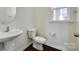 Convenient half bathroom features a pedestal sink, toilet, and modern fixtures at 4051 Whittier Ln, Fort Mill, SC 29708