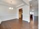 Bright living room featuring hardwood floors, a decorative chandelier, and views into the modern kitchen at 4051 Whittier Ln, Fort Mill, SC 29708