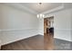 Bright living room with hardwood floors, a decorative chandelier, and an open entrance to the kitchen at 4051 Whittier Ln, Fort Mill, SC 29708