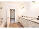 Bathroom with double sink vanity with granite countertop and tiled floor, plus an open doorway to a bedroom at 4431 1St Street Nw Dr, Hickory, NC 28601