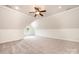 A spacious bedroom features a neutral carpet, a window with natural light, and a ceiling fan at 4431 1St Street Nw Dr, Hickory, NC 28601