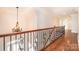 Hallway with wood floors, chandelier and wrought iron railing overlooking entry of home at 4431 1St Street Nw Dr, Hickory, NC 28601