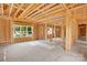 Unfinished living space featuring exposed studs, beams, and multiple windows offering views of the street at 4918 Buckingham Dr, Charlotte, NC 28209