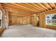 Unfinished living space featuring exposed studs, beams, staircase and a view of the neighborhood at 4918 Buckingham Dr, Charlotte, NC 28209