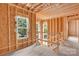 Unfinished second floor featuring open spaces and natural light from windows overlooking the surrounding trees at 4918 Buckingham Dr, Charlotte, NC 28209