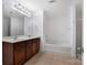 Bathroom featuring double sink vanity with wood cabinets, a shower-tub combo, and tile floors at 5008 Social Cir, Fort Mill, SC 29707