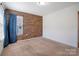 Bedroom with wood accent wall, carpet, and natural light from window with blue curtains at 5008 Social Cir, Fort Mill, SC 29707