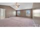 Spacious primary bedroom featuring two windows, neutral carpet, and a ceiling fan at 5008 Social Cir, Fort Mill, SC 29707