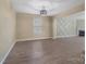 Open living room boasts wood floors, a designer accent wall, and a view to the fireplace in the adjacent room at 5008 Social Cir, Fort Mill, SC 29707