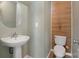 A simple, small powder room with a white vanity and toilet and a round mirror at 5008 Social Cir, Fort Mill, SC 29707
