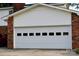 This garage features white paneled doors, and attached brick facade at 7448 Forney Hill Rd, Denver, NC 28037