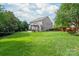 Beautiful backyard with mature trees, a pergola covered patio, and plenty of green space at 8115 Wilburn Ct, Charlotte, NC 28277