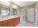 Bathroom featuring double sinks, wooden cabinets, and a walk-in shower at 8115 Wilburn Ct, Charlotte, NC 28277