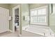 Bright bathroom showcasing a soaking tub, plantation shutters, and private toilet room at 8115 Wilburn Ct, Charlotte, NC 28277