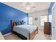 Bedroom features a bright blue accent wall, wooden bed frame, and two bright windows at 8115 Wilburn Ct, Charlotte, NC 28277