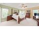 Spacious bedroom with a four-poster bed, ceiling fan, and lots of natural light at 8115 Wilburn Ct, Charlotte, NC 28277