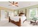 Bright bedroom featuring a four-poster bed, rocking chair, and ensuite bathroom at 8115 Wilburn Ct, Charlotte, NC 28277