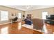 Large bonus room with hardwood floors, multiple seating areas, and a ceiling fan at 8115 Wilburn Ct, Charlotte, NC 28277