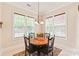 Cozy breakfast nook features a round table, decorative rug, and sunny windows with views of the backyard at 8115 Wilburn Ct, Charlotte, NC 28277