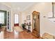 Inviting entryway with hardwood floors, grandfather clock, and a view into the adjacent office space at 8115 Wilburn Ct, Charlotte, NC 28277