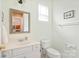 Well-lit half bathroom features a white vanity, toilet, and neutral walls with decorative accents at 8115 Wilburn Ct, Charlotte, NC 28277