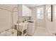 Bright laundry room featuring modern washing machine, sink, cabinet storage, and tile floors at 8115 Wilburn Ct, Charlotte, NC 28277