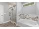 Bright bathroom featuring a glass enclosed shower with marble-look tile and separate soaking tub at 813 Montreat Dr, Dallas, NC 28034