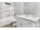 Bathroom featuring shower-tub combo with marble tile, and vanity with white cabinets at 813 Montreat Dr, Dallas, NC 28034