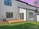 Exterior home view featuring a wooden deck, sliding glass door, white siding and a well-maintained green lawn at 8315 Adrian Ct, Charlotte, NC 28270