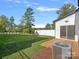 Exterior view of a home featuring a wooden deck, lush green grass, white privacy fence and mature trees at 8315 Adrian Ct, Charlotte, NC 28270