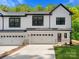 Modern white two-story townhome featuring black framed windows and two-car garage at 8315 Adrian Ct, Charlotte, NC 28270