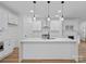 Modern kitchen featuring white cabinets, stainless steel appliances, large island and elegant pendant lighting at 8315 Adrian Ct, Charlotte, NC 28270