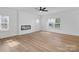 Bright living room featuring wood flooring, electric fireplace, large windows, and a ceiling fan at 8315 Adrian Ct, Charlotte, NC 28270