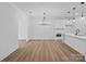 Open concept living space showcasing hardwood floors, modern lighting, and a seamless flow into the kitchen area at 8315 Adrian Ct, Charlotte, NC 28270