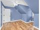 Upstairs bedroom featuring high, slanted, blue ceilings, a fan, and hardwood floors at 832 Kemp Rd, Mooresville, NC 28117