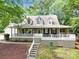 Charming home featuring a large front porch and well-manicured landscaping, offering curb appeal and outdoor enjoyment at 832 Kemp Rd, Mooresville, NC 28117