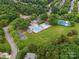 Aerial view of community pool, tennis courts, clubhouse, playground, parking and green space surrounded by trees at 8921 Whittingham Dr, Waxhaw, NC 28173