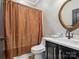 Cozy bathroom featuring a shower with curtain, toilet, and decorative mirror above a vanity with storage at 8921 Whittingham Dr, Waxhaw, NC 28173