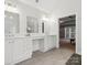 Bright bathroom with dual sinks, white cabinets, vanity space, and a view of the bedroom through an open doorway at 8921 Whittingham Dr, Waxhaw, NC 28173
