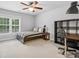 Bright bedroom featuring a twin bed with a desk, bookshelf, and a window providing natural light at 8921 Whittingham Dr, Waxhaw, NC 28173