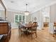 Formal dining room with a chandelier, hardwood floors, large windows, and classic furnishings for elegant meals at 8921 Whittingham Dr, Waxhaw, NC 28173