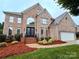 Charming two-story brick home with manicured lawn and black double-door entrance at 8921 Whittingham Dr, Waxhaw, NC 28173