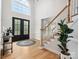 Bright foyer with hardwood floors, a staircase with white railings, and a soaring window above the door at 8921 Whittingham Dr, Waxhaw, NC 28173
