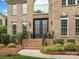 Inviting brick home featuring a grand entryway with black double doors and lush landscaping at 8921 Whittingham Dr, Waxhaw, NC 28173
