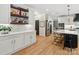 Elegant kitchen with a wet bar, custom shelving, and a view into the dining area at 8921 Whittingham Dr, Waxhaw, NC 28173