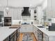 Beautiful kitchen with white countertops, custom cabinetry, a stylish range hood, and hardwood floors at 8921 Whittingham Dr, Waxhaw, NC 28173