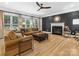 Inviting living room featuring hardwood floors, a fireplace, and abundant natural light from large windows at 8921 Whittingham Dr, Waxhaw, NC 28173