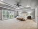Spacious main bedroom with a tray ceiling, plush carpet, a large window, and a comfortable seating area at 8921 Whittingham Dr, Waxhaw, NC 28173