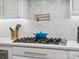 Close-up of a modern stovetop with pot filler faucet and herringbone backsplash in the kitchen at 8921 Whittingham Dr, Waxhaw, NC 28173